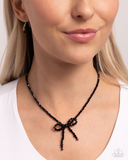 Somebody I Used to BOW - Black

P2RE-BKXX-484XX
Infused along an invisible string, a collection of faceted, reflective black beads loop and curl into a beautiful bow that rests along the collar for a refined centerpiece. Features an adjustable clasp closu